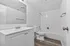 Modern bathroom with sleek white fixtures, spacious vanity, and elegant tiled shower.
