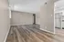 Bright, open-concept living area with modern hardwood floors and neutral walls, seamlessly connected to a contemporary kitchen.