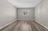 Bright, airy room with stylish vinyl flooring and a large window overlooking lush greenery.