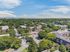 Vibrant aerial view of a lush residential neighborhood with apartment buildings surrounded by abundant greenery and clear blue skies.