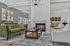 Elegant living room featuring a plush green sofa, stylish armchairs, modern fireplace, and contemporary artwork for a luxurious atmosphere.