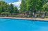 Inviting outdoor swimming pool with modern loungers and lush green surroundings, perfect for relaxation on a sunny day.