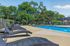 Inviting outdoor pool area with stylish lounge chairs and lush greenery, perfect for relaxation and leisure.