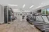 Modern fitness center with state-of-the-art exercise equipment, including treadmills, ellipticals, and weight machines, accented by natural light and stylish decor.