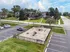 Charming apartment exterior featuring a fenced-in playground, lush green lawns, and ample parking in a peaceful residential area.