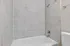 Elegant bathroom featuring luxurious marble-tiled shower and bathtub with modern fixtures.