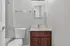 Modern bathroom featuring minimalist design with wood vanity, sleek fixtures, and elegant marble tile accents.