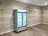 Contemporary storage area with sleek double glass-door cooler and ample shelving for organized living.