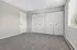Bright and spacious bedroom with plush carpeting, ample closet space, and soft natural light from large windows.