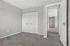 Bright bedroom with plush carpet, ample closet space, and neutral walls offering a modern, inviting ambiance.