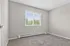 Inviting bedroom with plush carpeting and a large window offering natural light and scenic views.