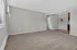 Inviting living space with plush carpeting, neutral walls, and abundant natural light from a large window, ideal for cozy gatherings.
