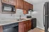 Modern kitchen with rich wooden cabinets, sleek black appliances, and a polished dual sink, perfect for stylish living.