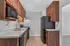 Contemporary kitchen with sleek black appliances, modern wooden cabinets, and elegant countertops.