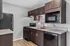 Modern kitchen with sleek dark cabinets, granite countertops, and stainless steel appliances, perfect for culinary enthusiasts.