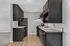 Modern kitchen with sleek dark cabinets, stainless steel appliances, and spacious countertops, seamlessly flowing into the open living area with warm wood flooring.