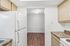 Bright kitchen with modern cabinetry, sleek countertops, and a spacious layout leading to a cozy dining area with elegant wood flooring.