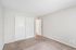 Bright and airy bedroom with plush carpet and sleek sliding closet doors, offering a modern and inviting space.