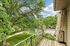 Charming balcony view with lush green trees and a peaceful neighborhood setting.
