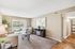 Bright and inviting living room with cozy carpet, modern decor, and glass doors opening to a greenery view.