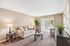 Bright and inviting living room with elegant neutral tones, featuring a comfortable sofa, stylish lamps, and large sliding glass doors for abundant natural light.