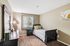 Inviting bedroom with cozy twin bed, elegant dark wood furniture, and sunlit window in a serene setting.