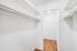 Spacious walk-in closet with sleek wooden flooring and ample storage space for an organized lifestyle.