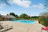 Inviting outdoor swimming pool area with sun loungers and lush greenery, perfect for relaxation and leisure.