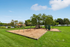 Charming outdoor playground with swings and slide set in lush green park surroundings, perfect for children and family fun.