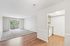 Inviting living space featuring a sunlit open layout, plush carpeting, and a modern kitchen with sleek wooden flooring.