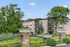 Charming apartment complex surrounded by lush greenery and modern stone accents, offering serene living and spacious balconies.