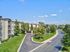 Charming apartment complex with lush greenery, offering a serene living environment with tree-lined streets and modern architecture.