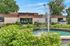 Welcoming leasing center surrounded by lush greenery and a vibrant water fountain, offering a charming entrance to residents.