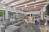 Contemporary lounge with sleek gray sofas, wooden beams, and expansive windows showcasing outdoor patio views. Perfect blend of comfort and style in a communal setting.