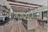 Modern communal space with sleek kitchen, elegant pendant lighting, and panoramic windows overlooking lush greenery.