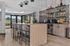 Contemporary kitchen design with sleek cabinetry, stylish open shelving, and an inviting breakfast bar in a well-lit space.