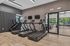 Modern apartment fitness center with state-of-the-art treadmills and StairMaster, sleek design, natural light, and vibrant outdoor view.