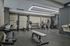 Modern fitness center with state-of-the-art exercise equipment, including dumbbells, a weight bench, and cardio machines, in a sleek, well-lit interior.