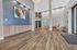 Elegant apartment lobby with high ceilings, modern artwork, and stylish sitting area on polished wooden floors.