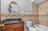 Elegant bathroom with modern fixtures, featuring a granite countertop, sleek vanity, and stylish tiled walls.