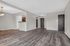 Modern open concept living area with elegant wood flooring, a cozy dining space, and a stylish kitchen entrance.