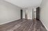 Spacious bedroom with elegant hardwood floors, neutral walls, and direct access to a modern bathroom and walk-in closet.