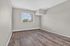 Bright and airy empty room with elegant wood flooring and large window offering a scenic view, perfect for a personalized touch in your new home.