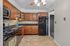 Elegant kitchen with cherry wood cabinets, modern appliances, and polished granite countertops, offering a warm and inviting culinary space.