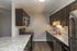 Modern kitchen with sleek dark cabinetry, granite countertops, and stainless steel appliances.