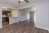 Spacious open-concept apartment with elegant wood flooring, modern stainless steel kitchen, and bright natural light.