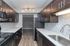 Sleek modern kitchen with dark wood cabinets, stainless steel appliances, and elegant tile backsplash.