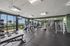 Modern gym with panoramic city views, featuring state-of-the-art fitness equipment and spacious workout area.