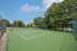 Lush outdoor tennis court surrounded by greenery, perfect for recreational play and relaxation.