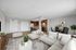 Bright, open-concept living area with modern kitchen, stylish dining nook, and cozy seating in a virtually staged apartment.